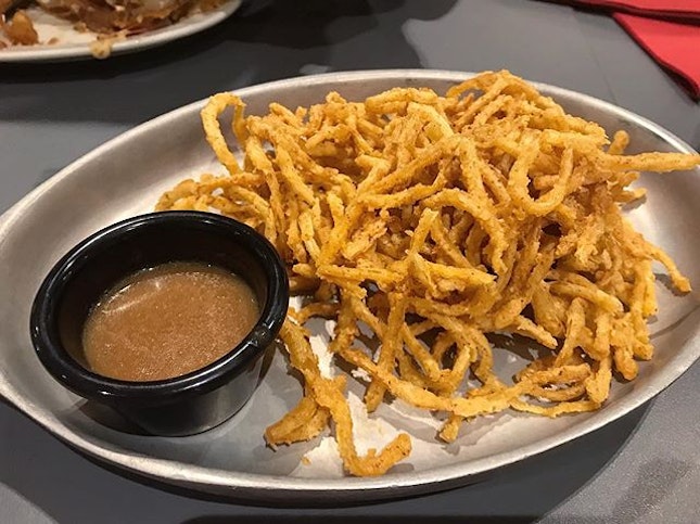 A platter of fried onions with delicious gravy to go with the steak
.