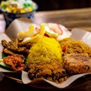 Nasi Kuning | fragrant turmeric rice with galangal fried chicken, fried vermicelli, omelette, fried potato cake, sweet and spicy fried tempe, garlic crackers, homemade sambal
