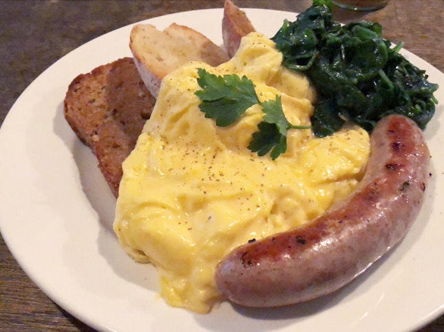 Scrambled Eggs on Toast with Pork Sausage and Wilted Spinach
