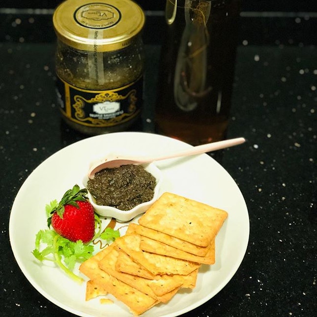 Black truffle sauce with crackers and rose tea.