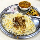 Mutton Biryani 
_
Soft, fluffy basmati rice, fork tender mutton, cold yogurt, a bowl of curry.