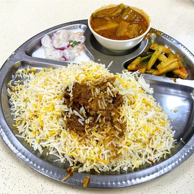 Mutton Biryani 
_
Soft, fluffy basmati rice, fork tender mutton, cold yogurt, a bowl of curry.