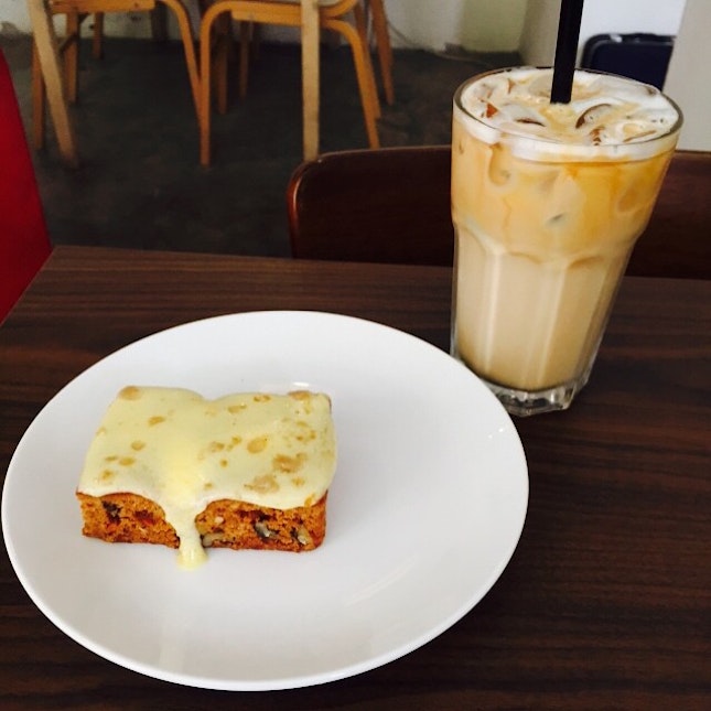 A nice small carrot cake with iced latte.
