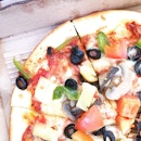Vegetarian pizza served with green capsicums, olives, cheese, pineapples & tomatoes and many other more flavors treated by FLC teacher: ms delonix ..