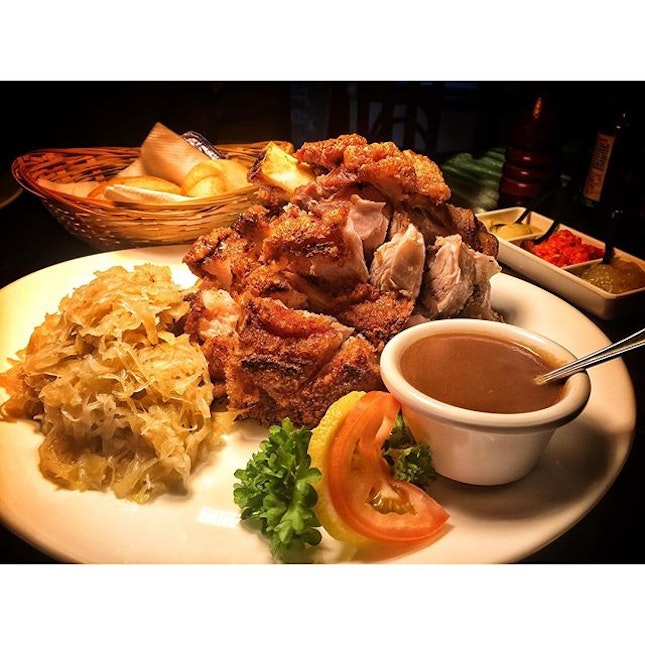 German Pork Knuckle with sauerkraut and bread, served with brown sauce, chilli, mustard, apple purée and SGD 44.90 Nett.