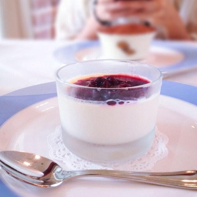 Panna cotta in the foreground and tiramisu in the background.