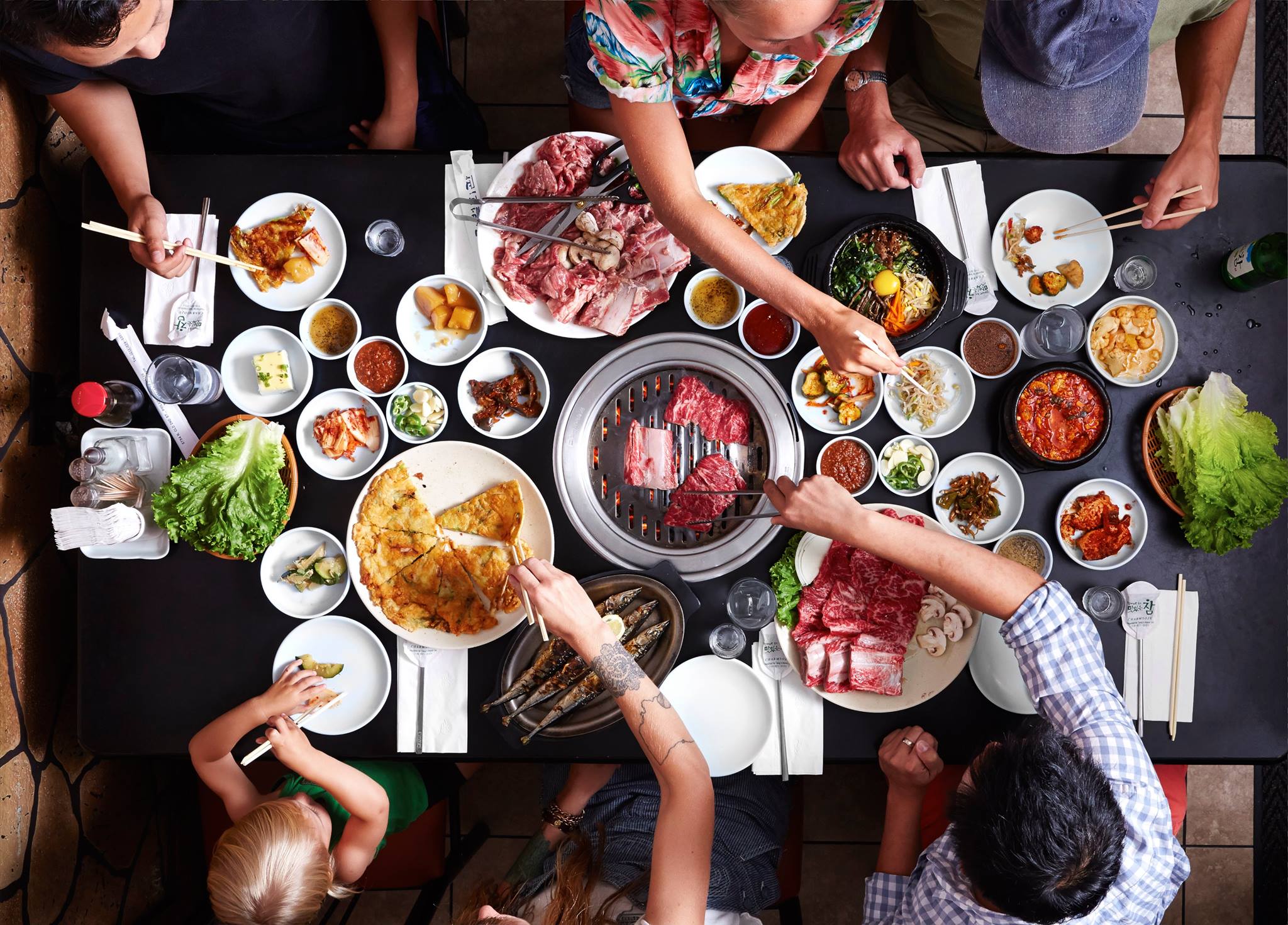 Готовить разную еду. Корейская Трапеза. Корейская еда в ресторане. Корейский стол с едой. Стол с едой и людьми.
